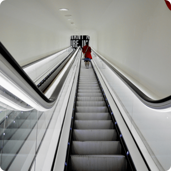 a person standing on a running escalator